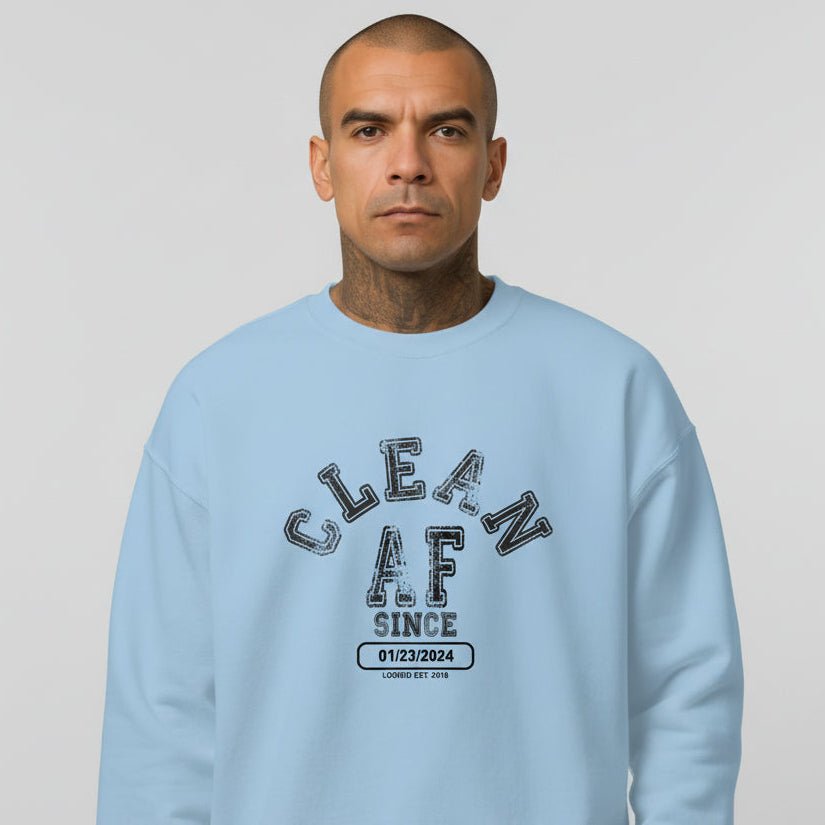 Flat lay of Loosid light blue Clean AF Since personalized sobriety sweatshirt with Recovery milestone β Loosid