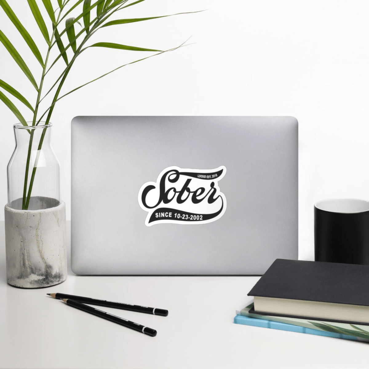 Loosid Sober Since personalized sobriety magnet displayed on a laptop in a styled desk workspace setting