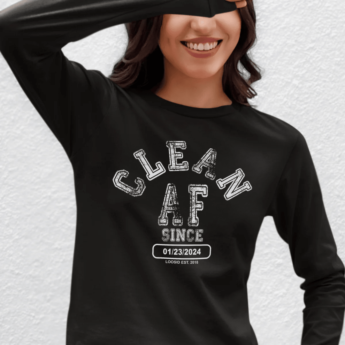 Person wearing a black sweatshirt with 'CLEAN AF SINCE' text on a textured white background